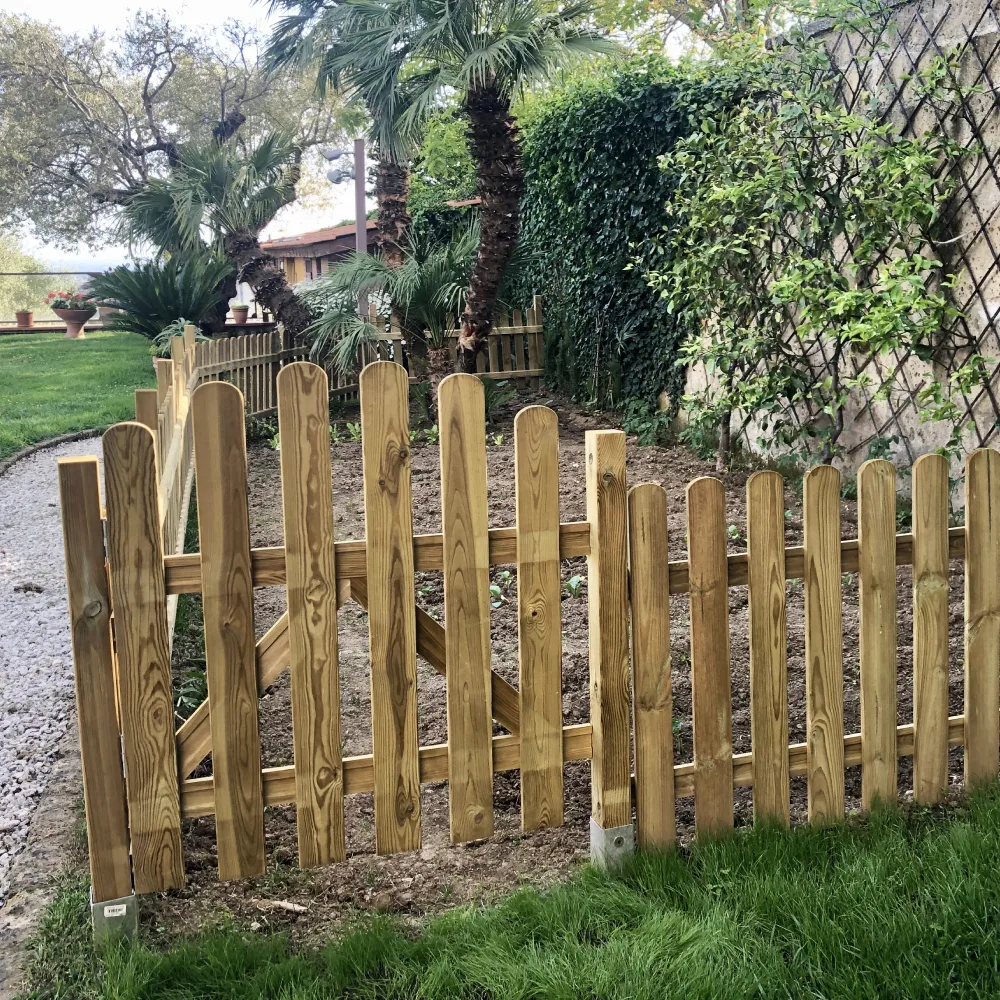 Palo di una recinzione in legno fissato a terra con staffa metallica