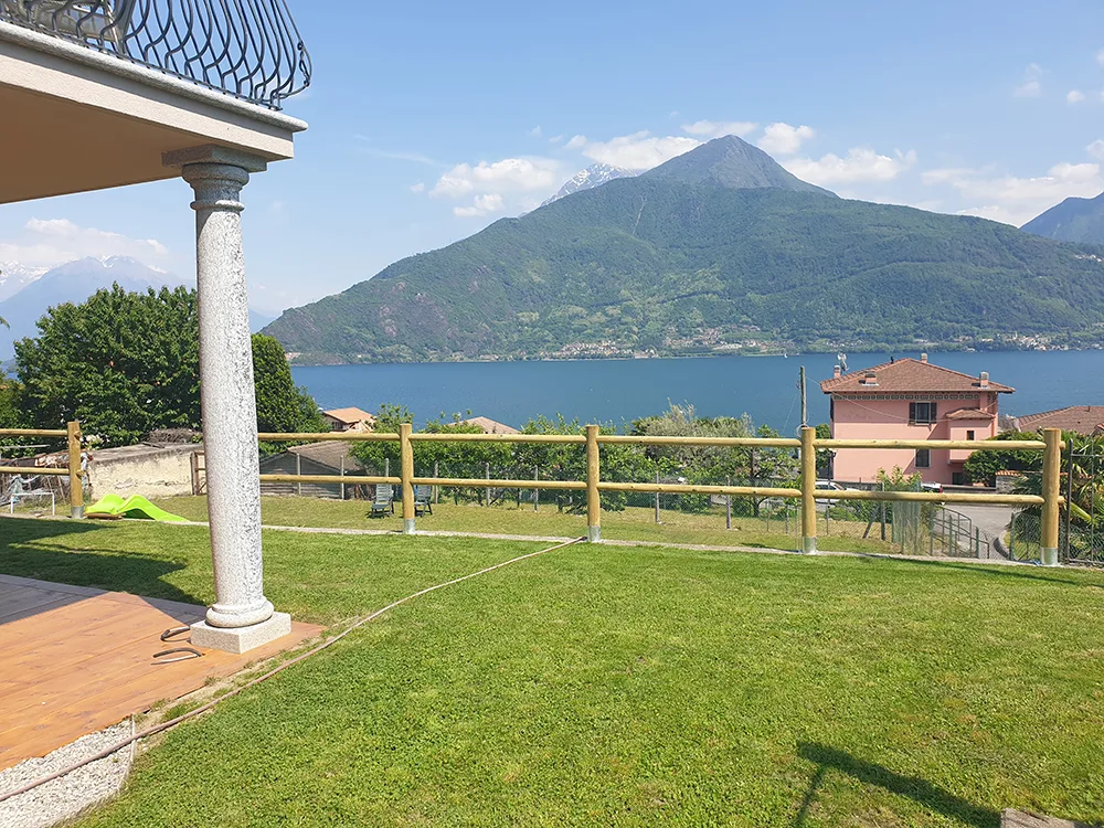 Staccionata a due traverse in castagno tornito che delimita un giardino