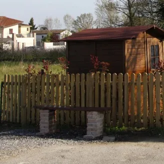Steccato in legno a palette verticali a delimitare un giardino