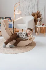 Bambino sdraiato nell'arco Montessori a dondolo in cameretta