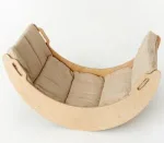 Cuscino beige sagomato sulla curva del dondolo Montessori in legno