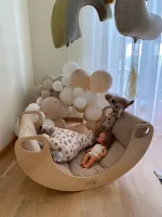 Bambina sdraiata nel dondolo CLASSIC con cuscino e palloncini