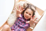 Bambina sorridente seduta nel dondolo Montessori CLASSIC