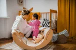 Mamma e bambina giocano con il dondolo Montessori SMILE in cameretta