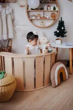 Bambino seduto nel dondolo Montessori SMILE in legno